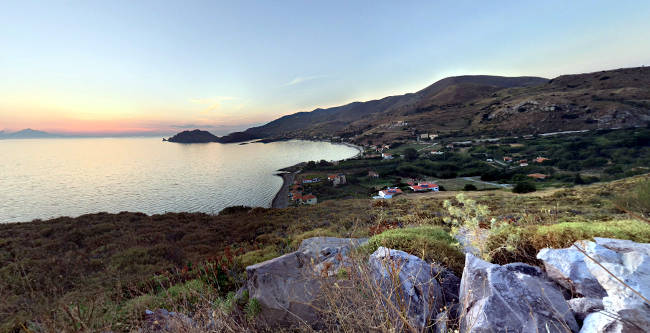 La baia di Agios Ioannis al tramonto scendendo dal villaggio di Kaspakas.