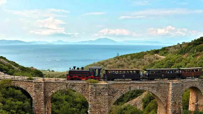 Il treno della ferrovia del Pelio affacciato sul golfo Pagaseo.