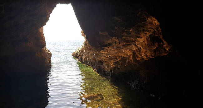 L'interno della Grotta di Filottete, dove turisti e visitatori si rinfrescano con un bagno.