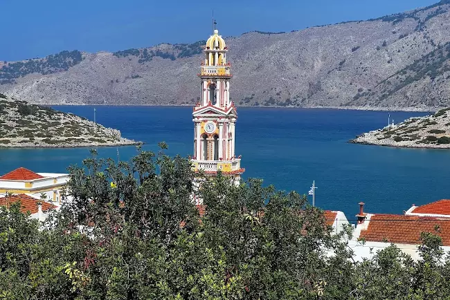 Il campanile del grande monastero di Panormitis davanti al mare di Symi.