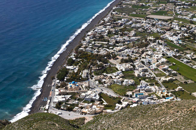 Perissa con la grande spiaggia scura, una delle più popolari di Santorini.