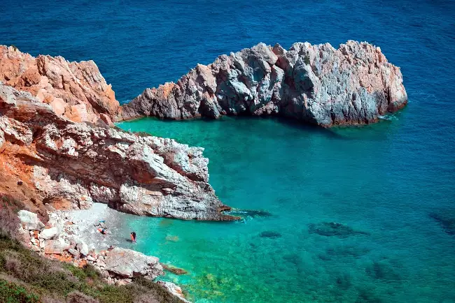 La bella spiaggia di Prioni, circondata dalle rocce e un mare cristallino.